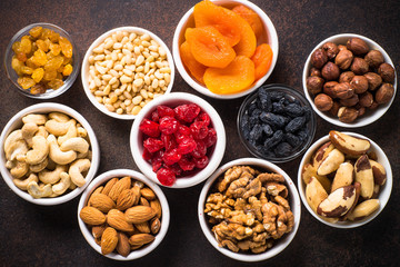 Nuts and dried fruits assortment on stone table top view.