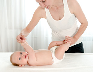 Mother massaging her infant baby