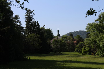 Fototapeta na wymiar Garden of Buchlovice castle with church tower, Czech republic