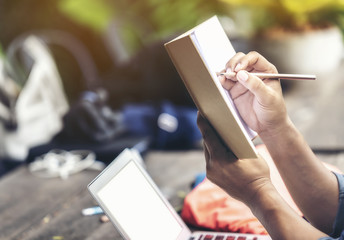 Man hand holding pencil and notebook to think of the design.