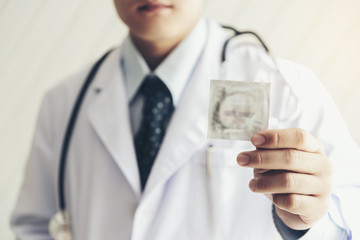 Doctor is holding condom for safe sex protection concept.To prevent the disease called 