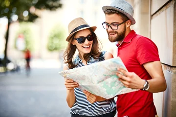 Foto op Canvas Young couple looking at map while on vacation during summer together © baranq