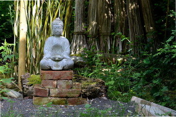 Buddha stone statue in a green garden