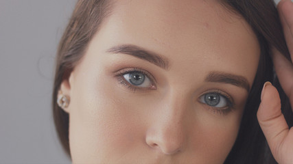 Fototapeta premium closeup of blue eyes of young woman looking at camera, Studio light ideal strobbing skin highlight