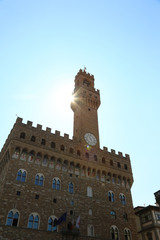Fototapeta premium Sunbeams and the high tower of the Palazzo Vecchio in Florence i