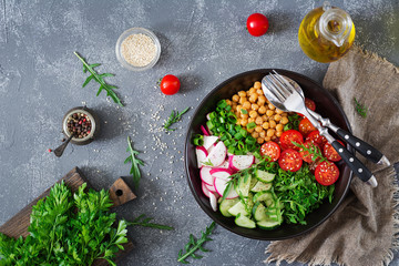Salad of chickpeas, tomatoes, cucumbers, radish and greens. Dietary food. Vegan salad. Top view. Flat lay. Buddha bowl