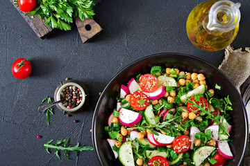 Salad of chickpeas, tomatoes, cucumbers, radish and greens. Dietary food. Vegan salad. Top view. Flat lay