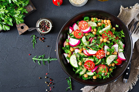 Salad of chickpeas, tomatoes, cucumbers, radish and greens. Dietary food. Vegan salad. Top view. Flat lay