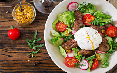 Warm salad from chicken liver, radish, cucumber, tomato and egg poached. Healthy food. Dietary menu. Top view. Flat lay.