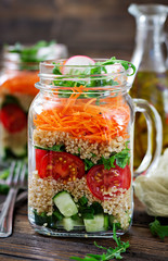 Salads with quinoa,  arugula, radish, tomatoes and cucumber in glass  jars on  wooden background.  Healthy food, diet, detox and vegetarian concept