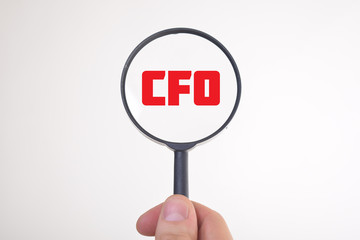 Businessman looking at a magnifying glass word:CFO