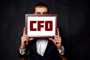 In the hands of a businessman a frame with the inscription:CFO