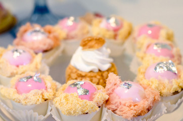   Candy Bar. Sweet round candy in pink and white glaze with raspberries on tartlets. Happy luxury birthday and wedding concept. Party sweets.