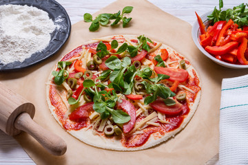 Raw pizza on kitcken table