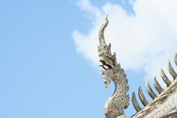 Fototapeta na wymiar Traditional Silver naga head sculpture on clear blue sky background