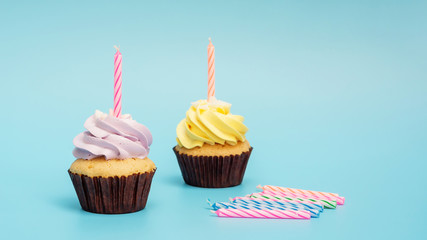 Cupcake and candle on a blue background.