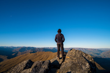 Fototapeta premium A young Asian man enjoying looking at the stunning scenery on the high mountain before sunset.