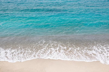 Fototapeta na wymiar Top view of a beach, blue ocean waves, sand and water