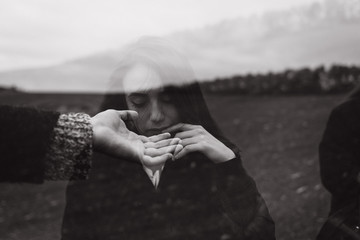 Dramatic double exposure effects on men's hand combined with portrait of beautiful girl. Vintage sepia style. Conceptual, abstract. Loneliness, freedom, dreaming. Relaxing in the wavy world of dreams.