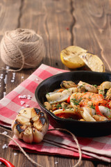 shrimp mussels and squid on frying pan with garlic and lemon