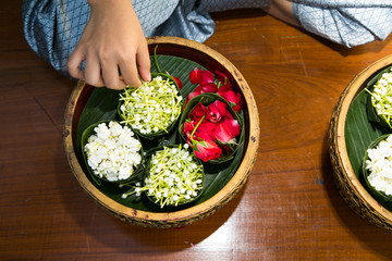 Thai woman making a tradition Thai flowers garland