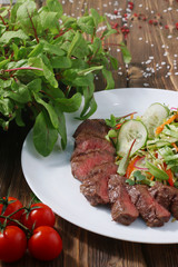fillet mignon with salad  on rustick wooden background