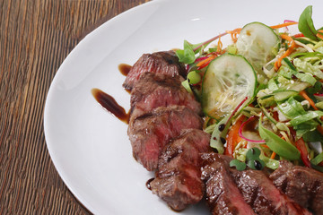 fillet mignon with salad close up on wooden background