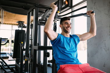Fit man exercising at the gym on a machine