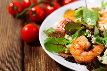 asty fried shrimp in salad on wood background  with cherry tomato