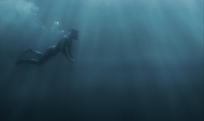 Obraz na płótnie Canvas Male freediver snorkeling in deep sea.