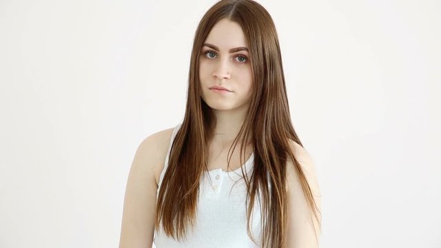 beautiful happy girl posing positively against a white wall and blowing kisses