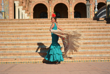 The beautiful girl in the green flamenco dress dances the flamenco in plaza de España, - obrazy, fototapety, plakaty