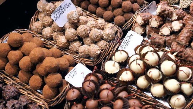 Dolly shot over Chocolate pralines display at La Boqueria market, Barcelona.
