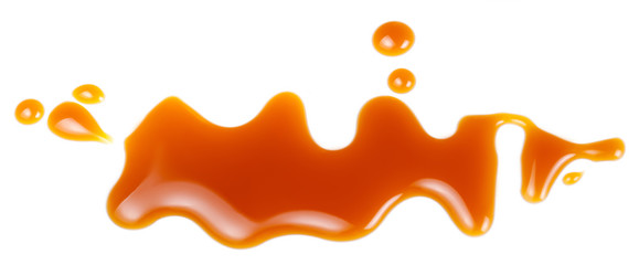 Sweet caramel sauce drop  isolated on white background close up. Golden Butterscotch toffee caramel...