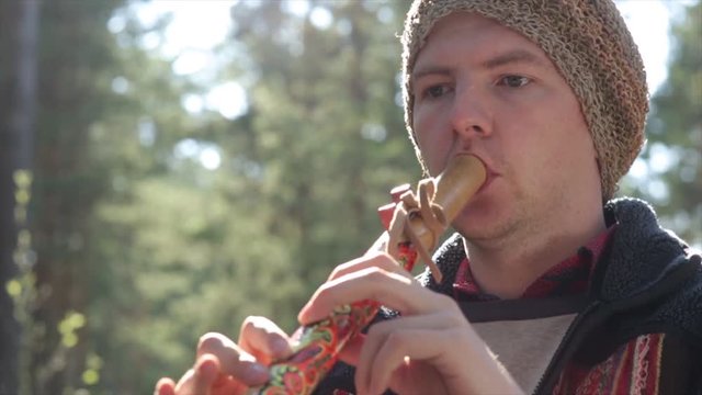 musician in ethnical costume plays on the peruvian flute.