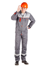 Full length portrait of a male builder in a helmet looking at camera over white wall background. repair, construction, building, people and maintenance concept.