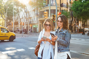 Fototapeta premium Two amazing women friends using mobile phone.