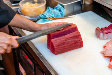 Japanese chef using knife cut the raw fish
