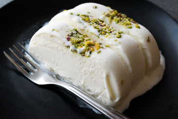 Turkish Maras Vanilla Ice Cream with Pistachio Powder Served Portion in Black Plate.