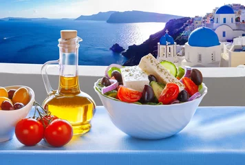 Crédence de cuisine en verre imprimé Santorin Salade grecque contre la célèbre église du village d& 39 Oia, île de Santorin en Grèce