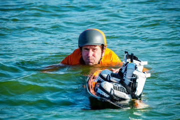 Obraz premium Funny wakeboarder swims with a wakeboard