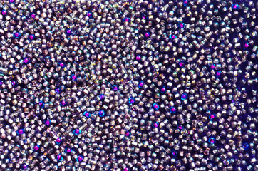 Glamorous background of shades of purple. Beautiful shiny texture. Glitter glass balls sewn on velvet. Imitation of diamonds. Multicolored beads on a velvet belt.