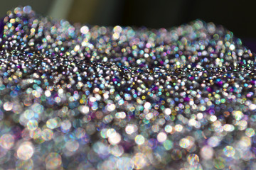 Fabric glitters in the light covered with luxurious beads. Wealth of colors in the glass. Beautiful shiny texture. Stars on a velvet belt. Glamorous light exude balls. Shine like brilliants, diamonds