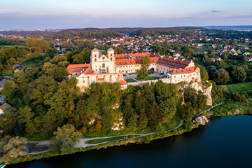 Fototapeta na wymiar Benedictine monastery on the rocky cliff in Tyniec near Cracow, Poland, and Vistula River. Aerial view at sunset