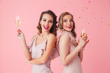 Two happy elegant women in dresses posing together with champagne © Drobot Dean
