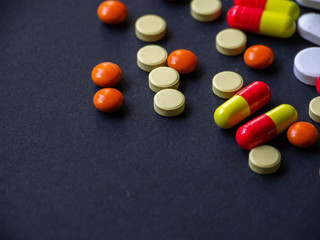 The pills are scattered on a black background. Tablets are scattered. Placebo.