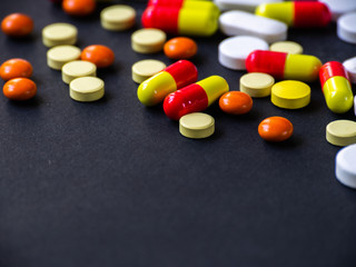 The pills are scattered on a black background. Tablets are scattered. Placebo.