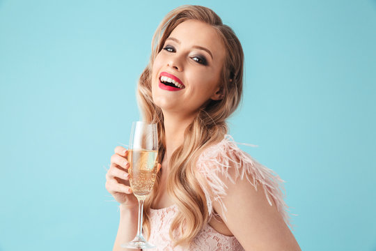 Side view of Cheerful woman in dress posing with champagne