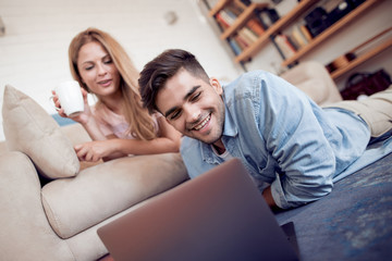 Beautiful young couple using laptop