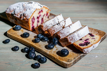 Homemade vanilla cupcake with fresh blueberries on a wooden background